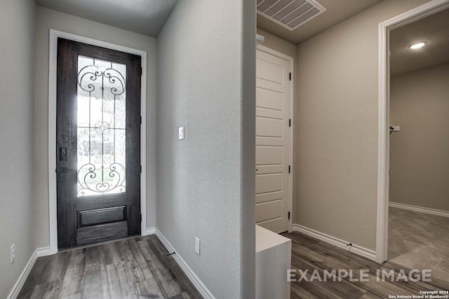 entryway with dark wood-style flooring, visible vents, and baseboards