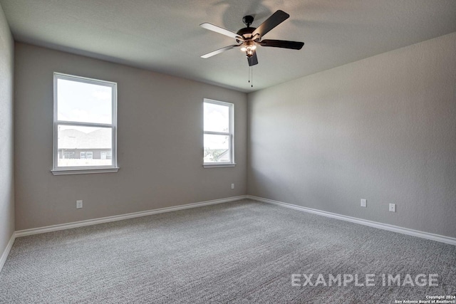 spare room with carpet floors, ceiling fan, and baseboards