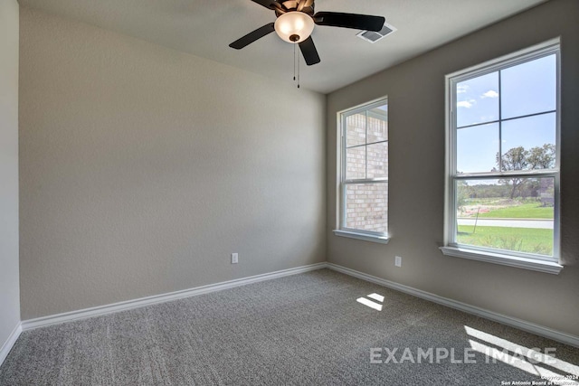 carpeted spare room with a ceiling fan, visible vents, and baseboards