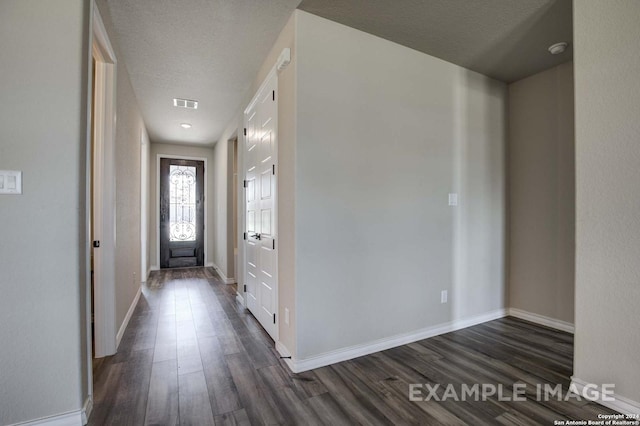 interior space featuring dark wood finished floors, a textured ceiling, and baseboards