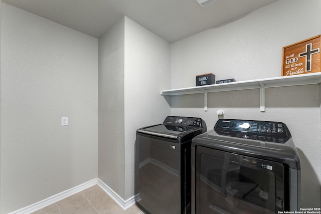 washroom with laundry area, light tile patterned floors, baseboards, and washer and clothes dryer