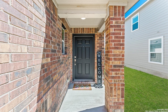 entrance to property featuring brick siding