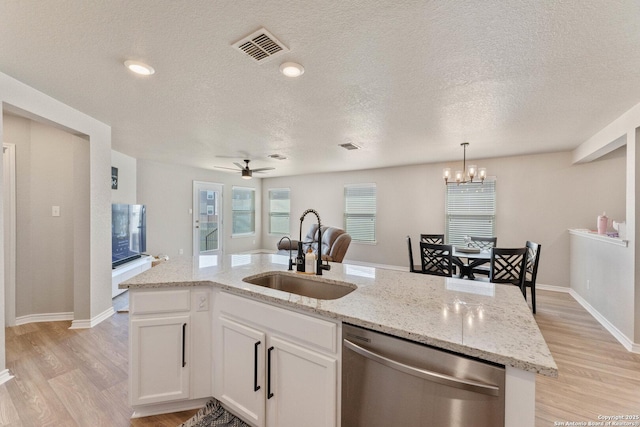 kitchen with stainless steel dishwasher, light wood-style flooring, a sink, and visible vents