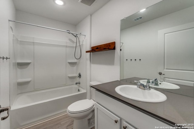 bathroom with shower / bath combination, visible vents, toilet, vanity, and wood finished floors