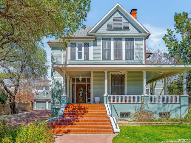 victorian home featuring covered porch and a chimney