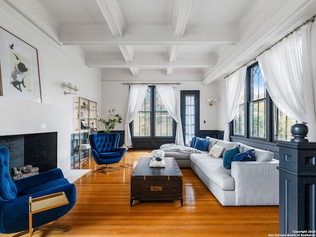 living room with beamed ceiling, coffered ceiling, and light wood-style floors