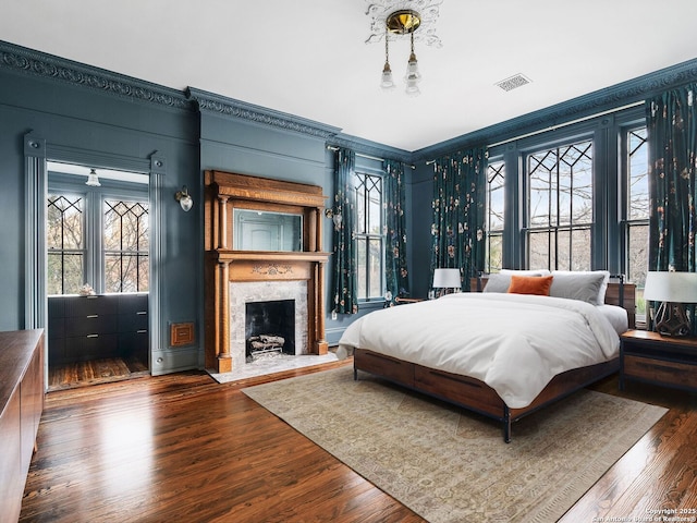 bedroom with a fireplace and wood finished floors