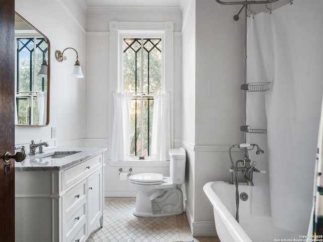 bathroom featuring plenty of natural light, toilet, vanity, and a soaking tub