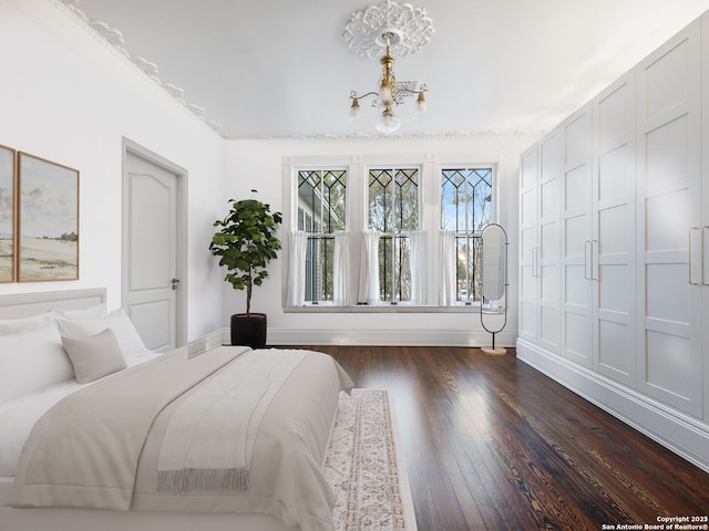 bedroom featuring an inviting chandelier, dark wood-style floors, and baseboards