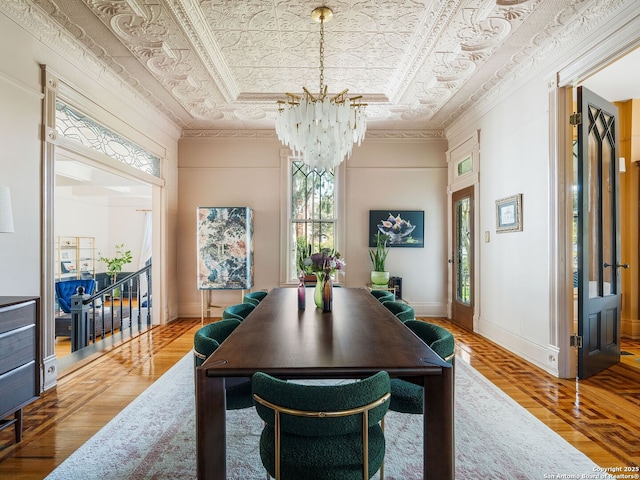 dining space featuring an ornate ceiling, a raised ceiling, baseboards, and ornamental molding