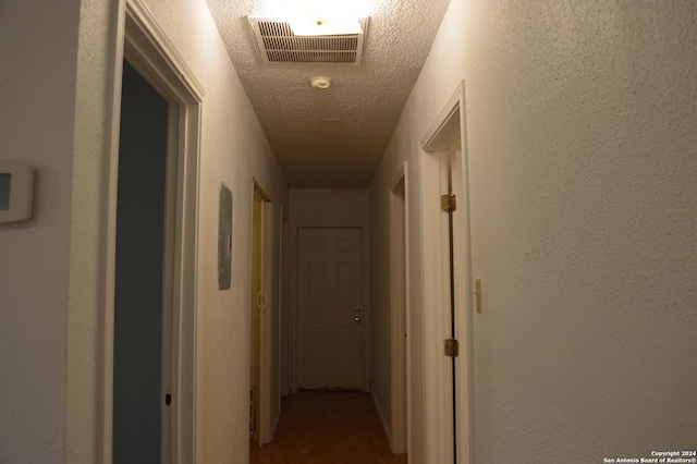 corridor featuring visible vents and a textured ceiling