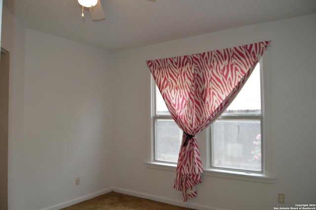 spare room featuring a ceiling fan, carpet flooring, and baseboards