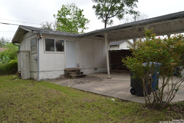 exterior space with a lawn, entry steps, crawl space, a patio area, and an attached carport