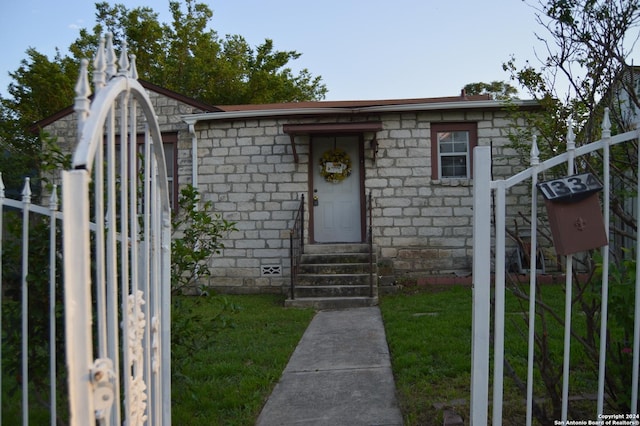 view of front facade featuring entry steps, crawl space, fence, and a front lawn