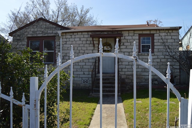 bungalow-style home with a front yard, fence, and entry steps