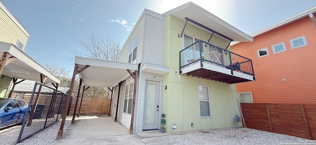 back of house featuring a balcony and fence