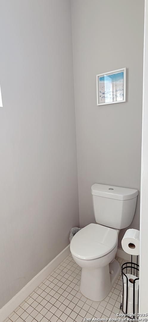 bathroom featuring tile patterned floors, toilet, and baseboards