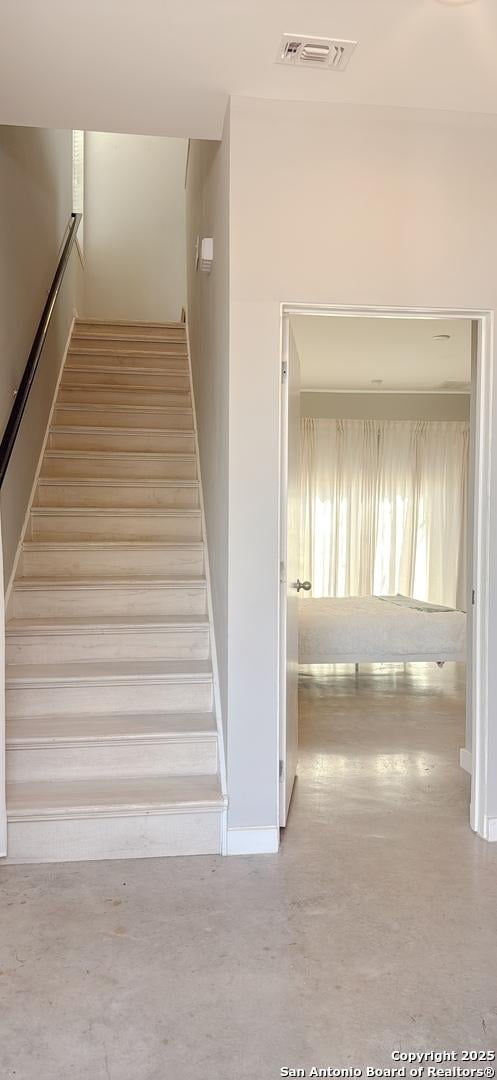 stairs featuring visible vents and concrete flooring