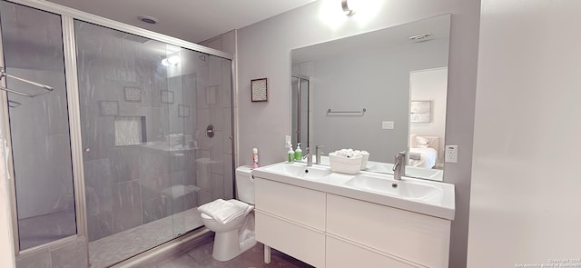 bathroom with a stall shower, a sink, toilet, and double vanity