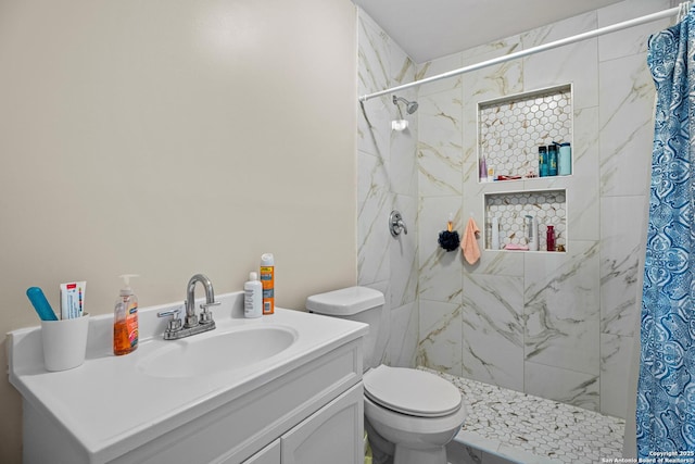 full bath with vanity, toilet, and a tile shower