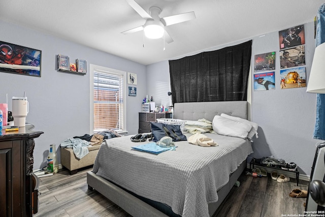 bedroom featuring ceiling fan, baseboards, and wood finished floors