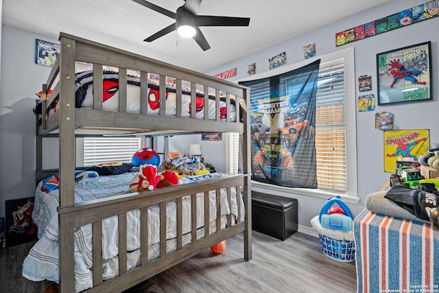 bedroom with baseboards, wood finished floors, and a ceiling fan