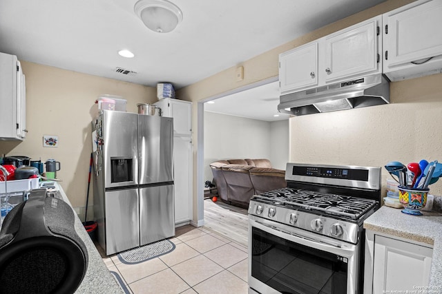 kitchen with visible vents, light countertops, white cabinets, under cabinet range hood, and appliances with stainless steel finishes