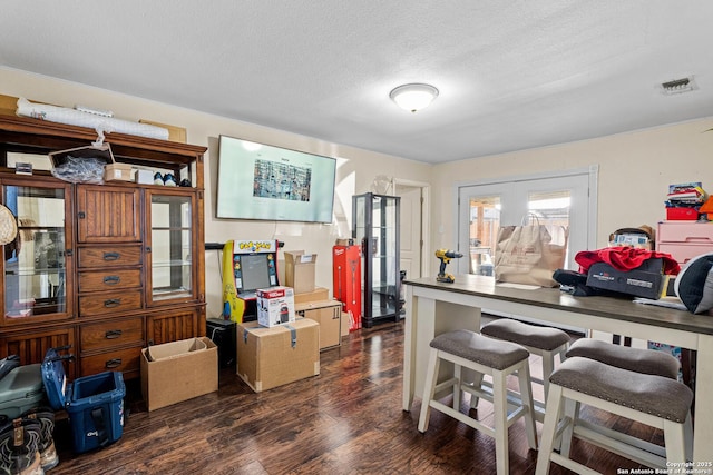 kitchen with dark wood finished floors, visible vents, and a textured ceiling