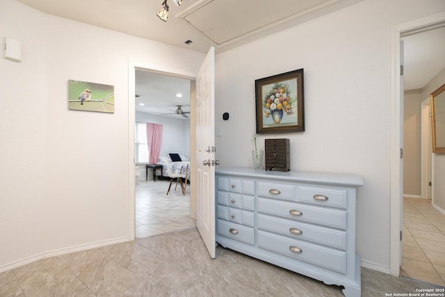 hallway with attic access and baseboards