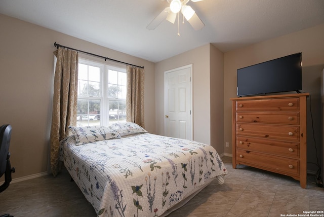 bedroom featuring ceiling fan and baseboards