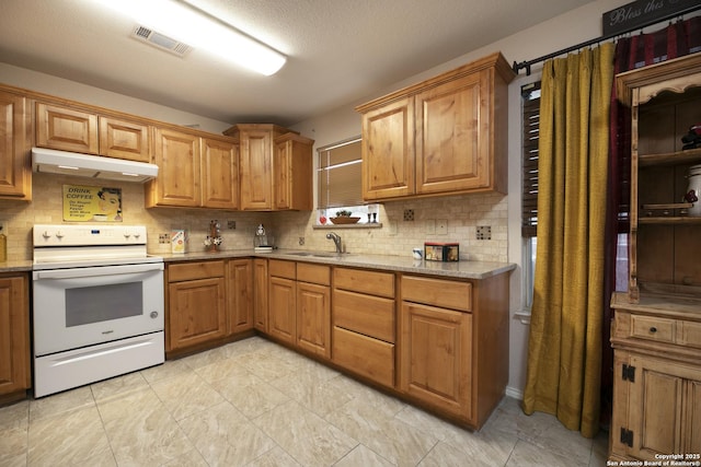 kitchen featuring visible vents, decorative backsplash, electric stove, under cabinet range hood, and a sink