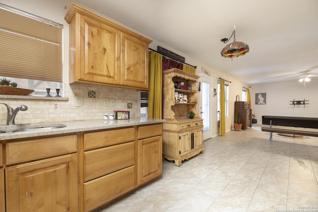 kitchen featuring light stone counters, open floor plan, a sink, open shelves, and backsplash