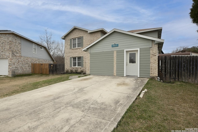 traditional-style home featuring driveway, brick siding, a front lawn, and fence