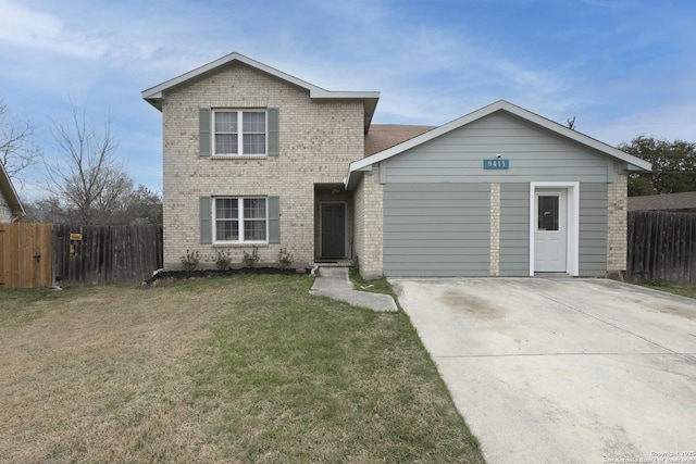 traditional-style home featuring brick siding, a front lawn, and fence