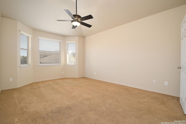 empty room featuring ceiling fan, a wealth of natural light, and light colored carpet