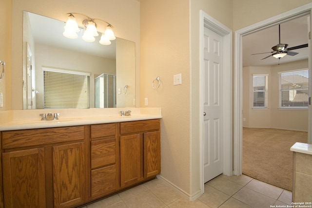 full bathroom with double vanity, a stall shower, a sink, and tile patterned floors