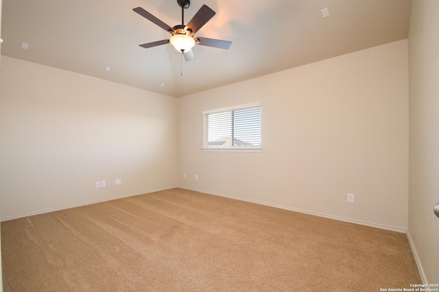 spare room with a ceiling fan, light carpet, vaulted ceiling, and baseboards