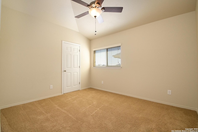 spare room with light carpet, vaulted ceiling, a ceiling fan, and baseboards