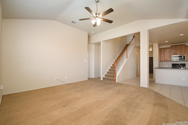 unfurnished living room with light carpet, light tile patterned floors, visible vents, lofted ceiling, and stairs