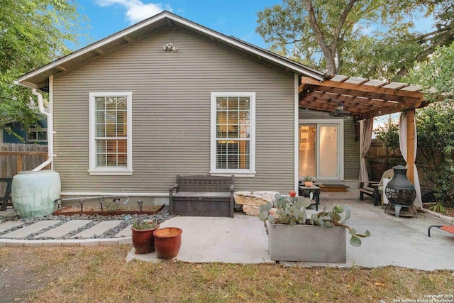 rear view of house featuring entry steps, a patio area, fence, and a pergola