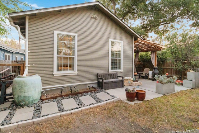 rear view of property with fence, a pergola, and a patio