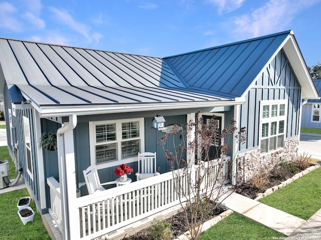 view of front of house with a standing seam roof, metal roof, a porch, and board and batten siding