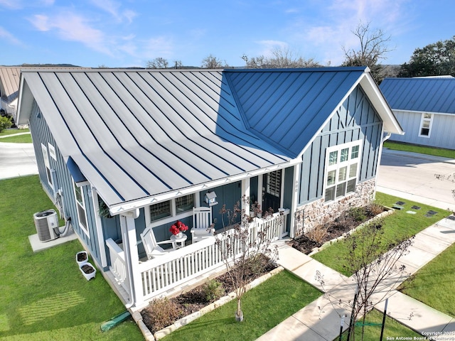 view of front facade featuring metal roof, a porch, and a standing seam roof