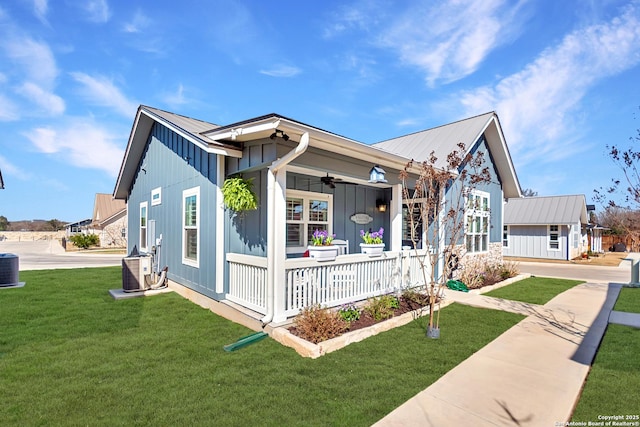 view of front of home with covered porch, ceiling fan, metal roof, and a front lawn