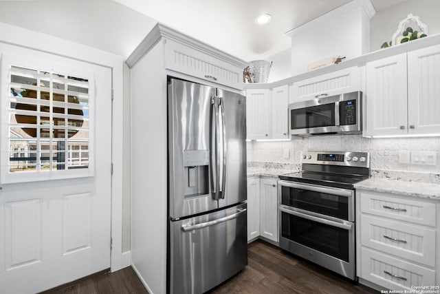 kitchen featuring appliances with stainless steel finishes, dark wood-style flooring, white cabinets, and backsplash