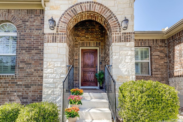 entrance to property with stone siding and brick siding