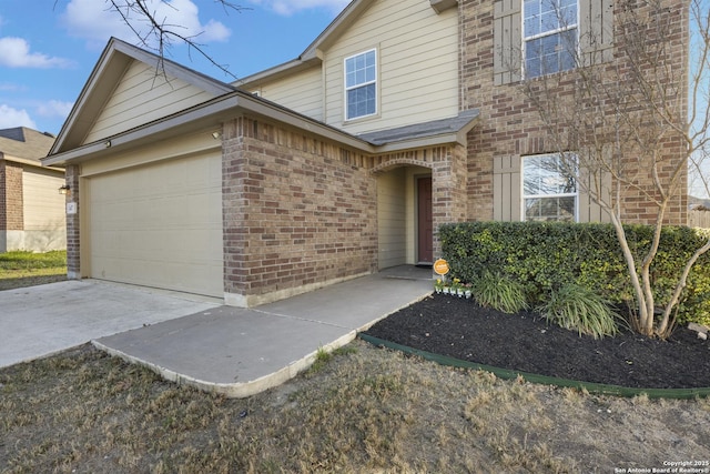 traditional-style home featuring concrete driveway, brick siding, and an attached garage