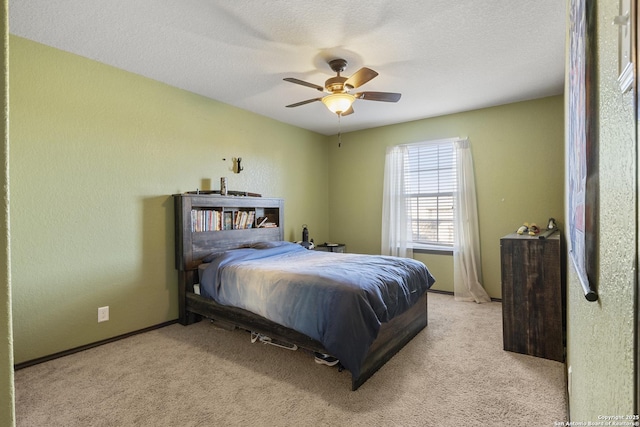 bedroom with light carpet, a textured wall, a textured ceiling, and baseboards