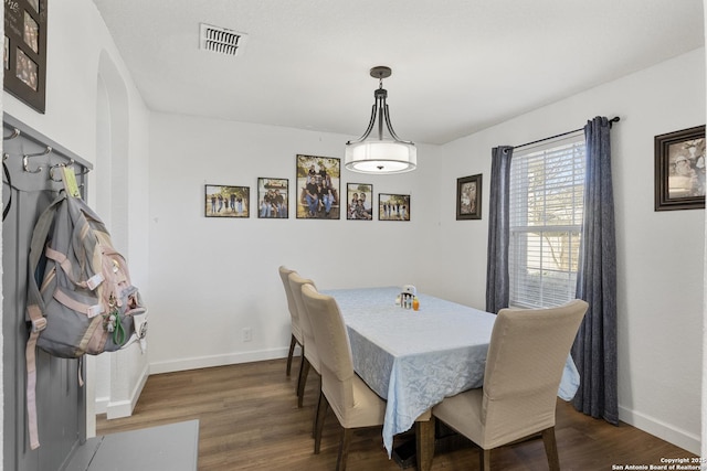 dining room featuring baseboards, visible vents, and wood finished floors