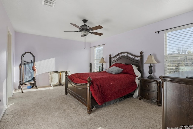 bedroom featuring carpet, multiple windows, visible vents, and a ceiling fan